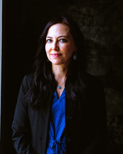 A woman in a blue dress looking at the camera